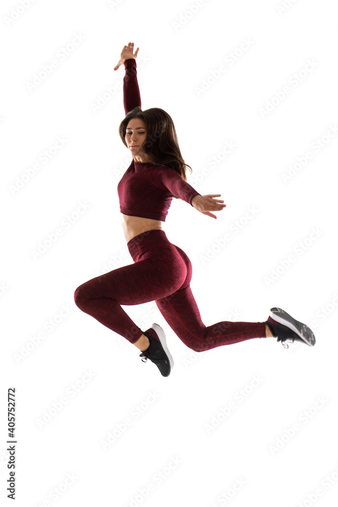 Fit, beautiful, young woman jumping isolated , Full length portrait of smiling sports woman jumping