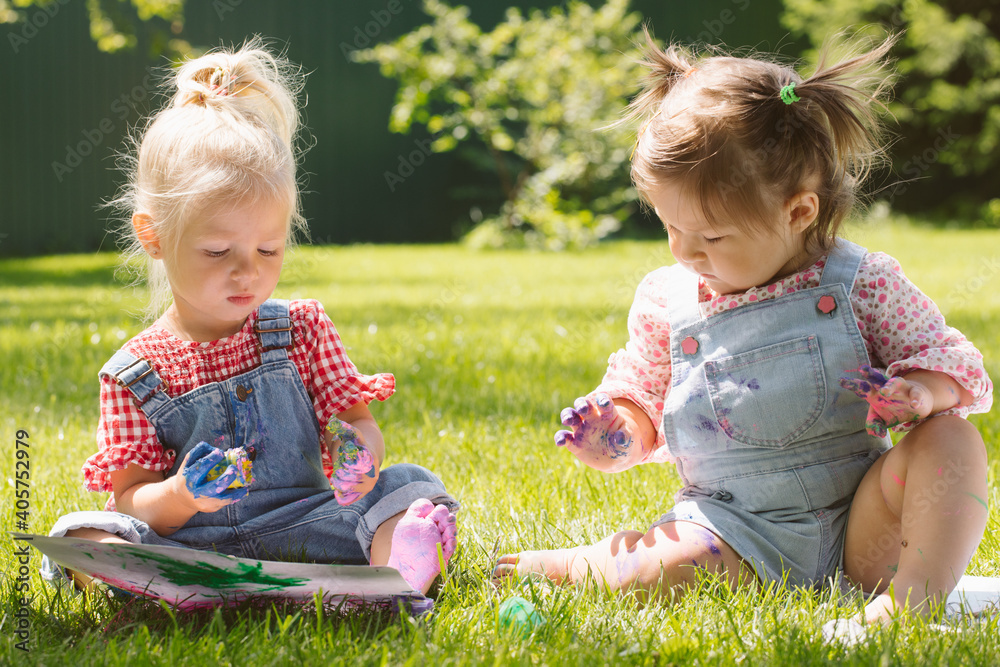 Two little girls sisters paint with finger paints Two little girls sisters paint with finger paints