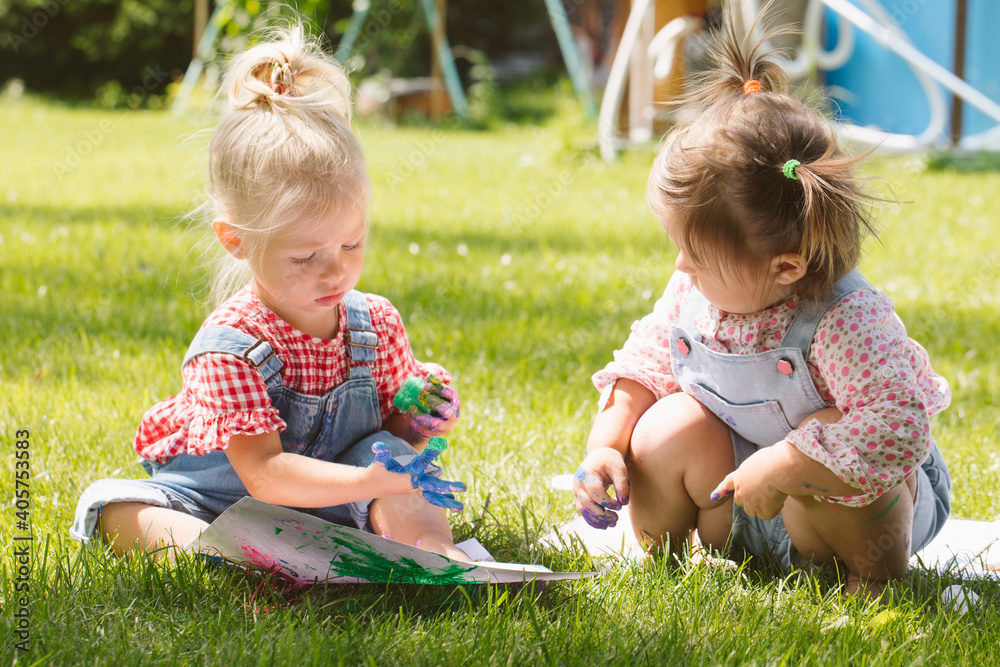 Two little girls sisters paint with finger paints Two little girls sisters paint with finger paints