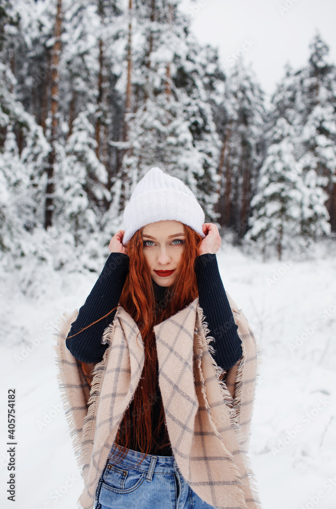 A young girl with long bright red hair on a winter background.A red-haired woman in a white cap. A young girl with long bright red hair on a winter background.A red-haired woman in a white cap.