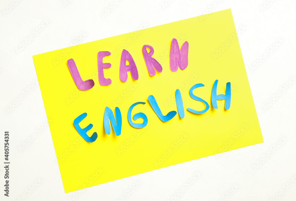 Note with phrase Learn English on white background, flat lay