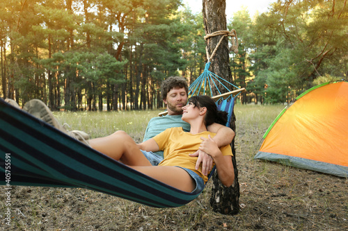 Lovely couple resting in comfortable hammock outdoors
