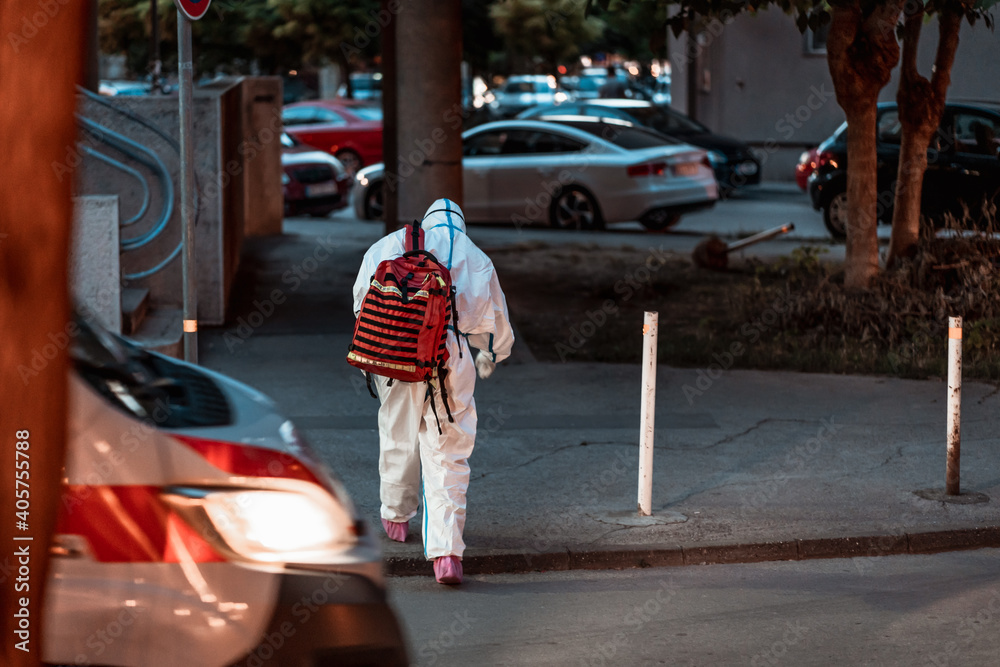 Obraz premium Tired medical worker going home after long day fighting corona virus covid-19. Health worker wearing personal protective equipment arrive to help during the COVID-19 Coronavirus pandemic.