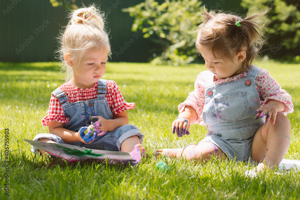 Two little girls sisters paint with finger paints Two little girls sisters paint with finger paints