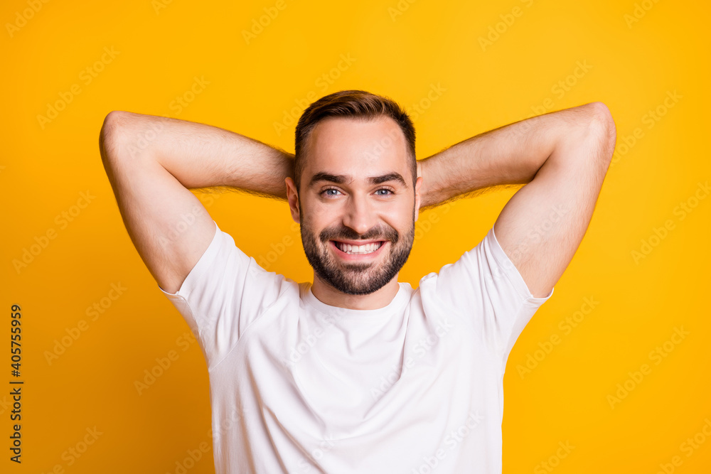 Portrait of optimistic guy lie down wear white t-shirt isolated on vibrant yellow color background Portrait of optimistic guy lie down wear white t-shirt isolated on vibrant yellow color background