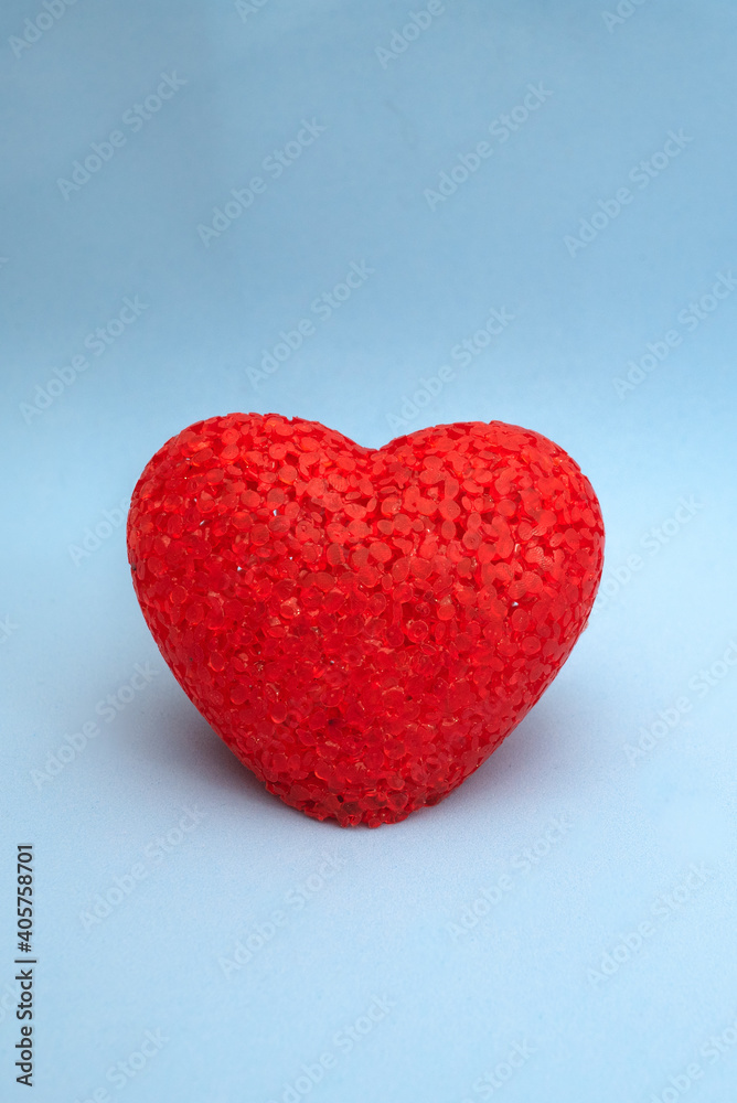 Red acrylic heart on blue background with place for text