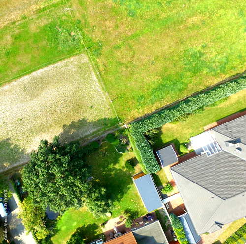 Plots with a meadow, a lawn, a detached house and a terraced house adjoin at one point, plot boundaries look like an abstract cross.
