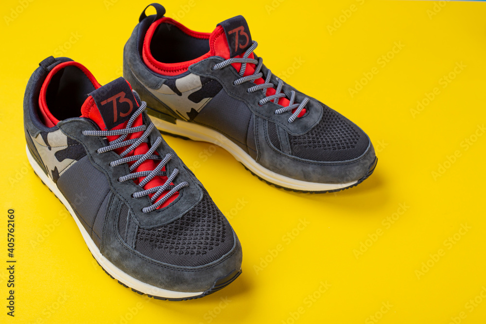 Insulated sneakers on a yellow background. Warm shoes concept. Insulated sneakers on a yellow background. Warm shoes concept.