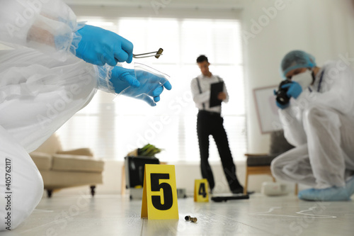 Investigators working at crime scene in messy room, closeup photo