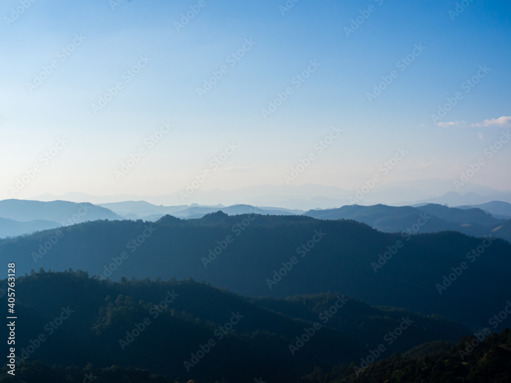 High place view of the many tall mountains and peaks that are arranged in layers in the morning and the mist covers the clear blue sky. High place view of the many tall mountains and peaks that are arranged in layers in the morning and the mist covers the clear blue sky.