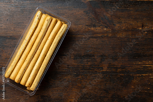 Homemade Italian Grissini Breadsticks on a wood background. Space for text.