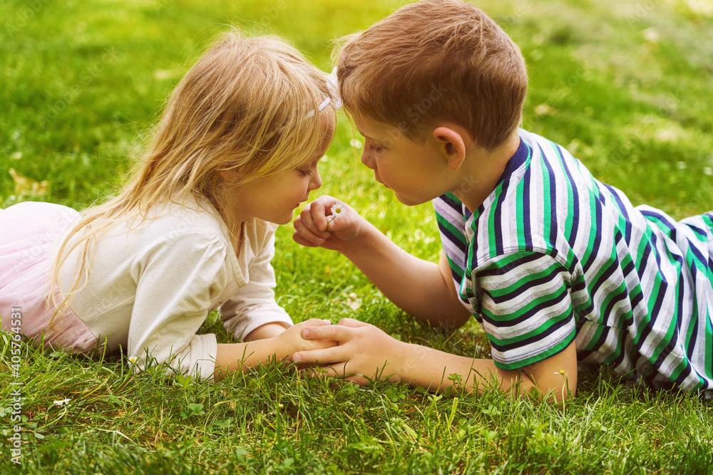 children lying on the green grass in the Park. The interaction of the children children lying on the green grass in the Park. The interaction of the children