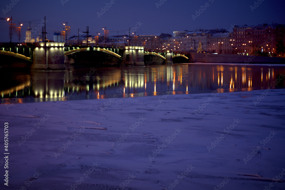 View of the Neva River, Birzhevoy Bridge and Petrogradsky Island on a winter evening in St. Petersburg, Russia.