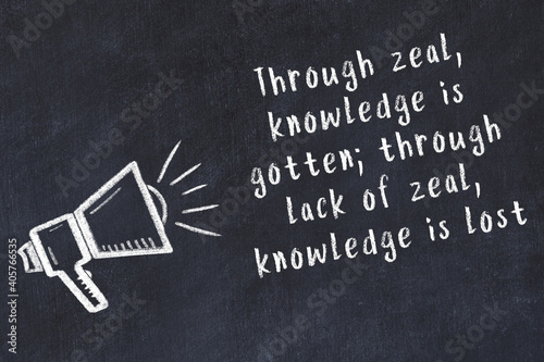 Fotografie Chalk loudspeaker and wise quote on black desk