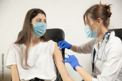 Prevention. Close up doctor or nurse giving vaccine to patient using the syringe injected. Works in face mask. Protection against coronavirus, COVID-19 pandemic and pneumonia. Healthcare, medicine.