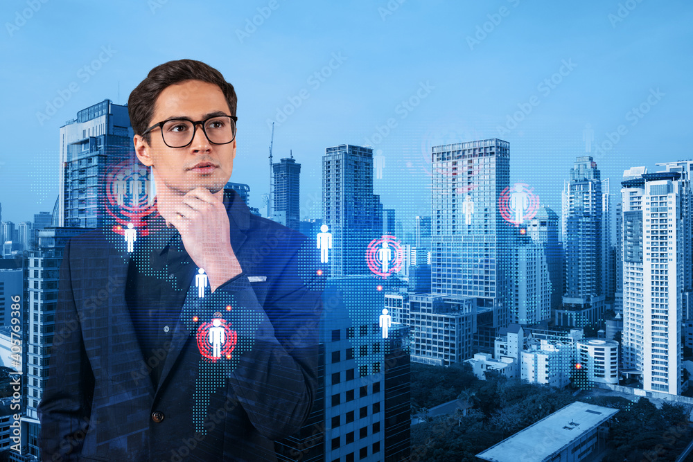 Handsome eastern HR director at international company is thinking about efficient strategy to recruit highly qualified specialists. Social media and marketing hologram icons over Bangkok background. Handsome eastern HR director at international company is thinking about efficient strategy to recruit highly qualified specialists. Social media and marketing hologram icons over Bangkok background.