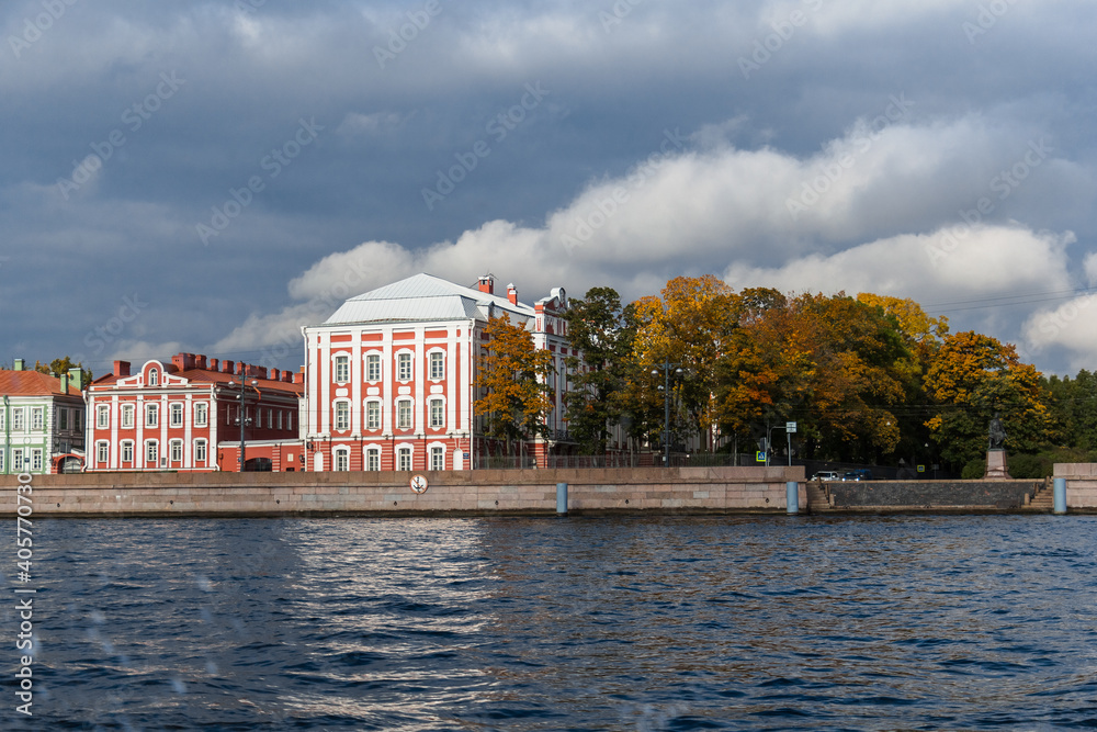 Universitetskaya embankment in St. Petersburg. Facade of houses. View from the water. Sunny day. Autumn.