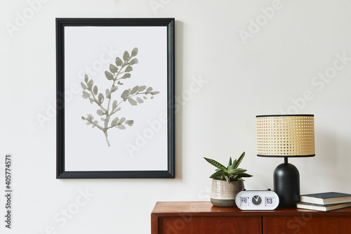 Retro modern compositon of living room interior with design teak commode  black mock up poster frame  clock  plant  decoration  white wall and personal accessories. Template.