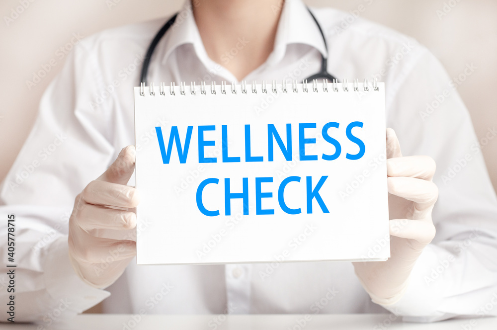 Doctor showing a card with text WELLNESS CHECK, medicine concept Doctor showing a card with text WELLNESS CHECK, medicine concept