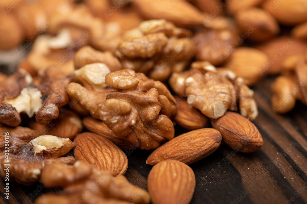 Almonds and walnuts scattered on the table. Close-up, selective focus. Almonds and walnuts scattered on the table. Close-up, selective focus.