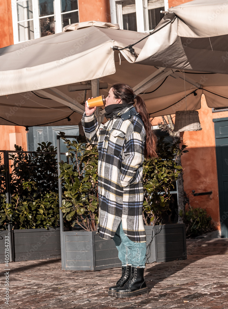 woman drinking a cup of coffee in a sunny winter day woman drinking a cup of coffee in a sunny winter day