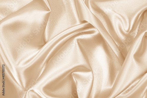 Beige cream vanilla light brown silk satin fabric. Soft wavy folds in the fabric. Wedding, anniversary, valentine, love, tender. Beautiful abstract background with space for your design.