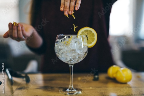 Coctel de ginebra con limón. Persona preparando copa de alcohol sobre barra. Bebida espirituosa. Camarero