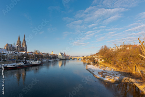 The famous skyline of the bavarian town Regensburg with the danube river on sunny winter morning with snow and ice