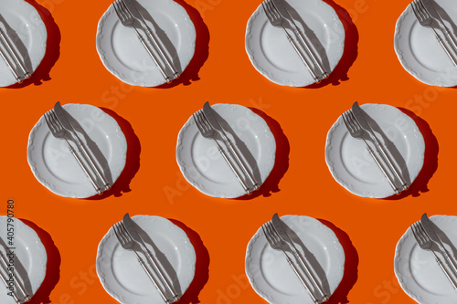 Minimal pattern with plate and tableware at orange background