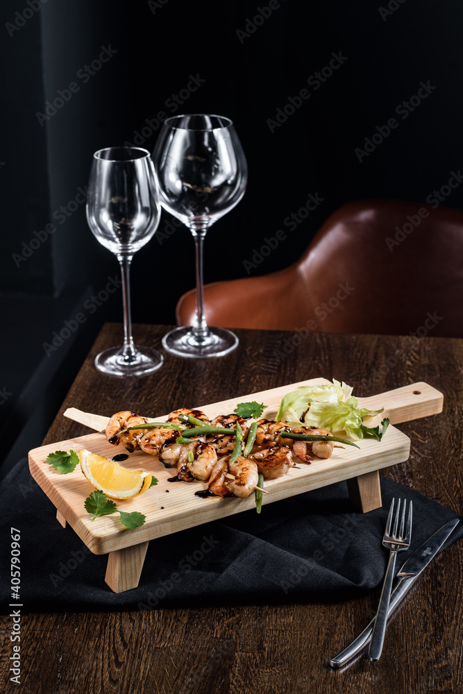 Board with snacks and glass glasses served on the table on a black background