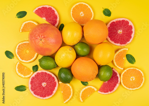 Flat lay oranges, lemon, lime with grapefruit on a yellow background in a high resolution. Ripe citrus fruit 