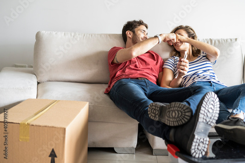 Smiling young couple relaxing on sofa in their new house
