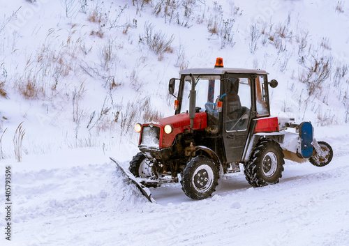 Snowblower removes snow. Tractor clears the path after heavy snowfall.