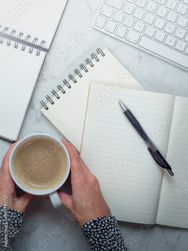 White workplace top view. Empty Notebooks on the table. On the desktop are notebooks, coffee and pen. Modern work or study postation for business Concept of writing