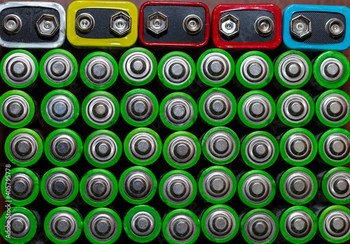 Used alkaline batteries AA size format of different brands lying in a rows. top view background texture of electric batteries and accumulators AA. AA packed close to each other. Used AA batteries  