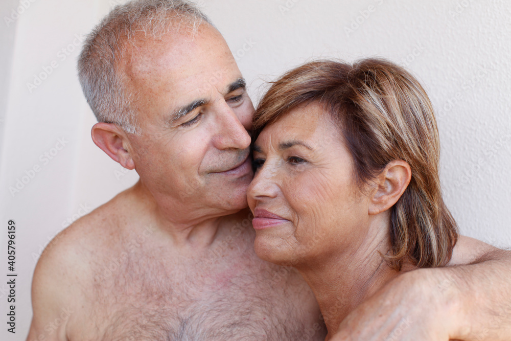Ritratto stretto di coppia a torso nudo che si abbraccia e si coccola intimamente 