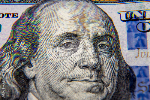 A close-up close-up shot of Benjamin Franklin's face on a $ 100 bill....