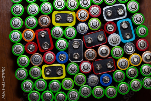 Used alkaline batteries AA size format of different brands lying in a rows. top view background texture of electric batteries and accumulators AA. AA packed close to each other. Used AA batteries  