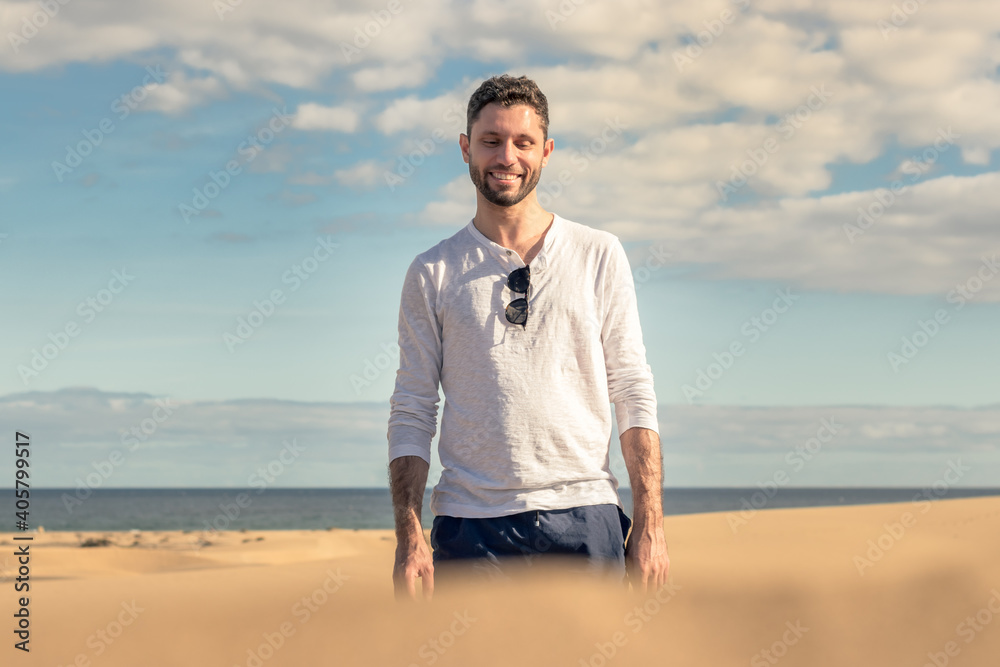Young man walking in the dunes of Maspalomas in Gran Canaria Young man walking in the dunes of Maspalomas in Gran Canaria
