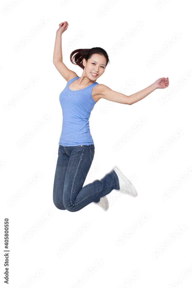 Young woman jumping in air with arms outstretched