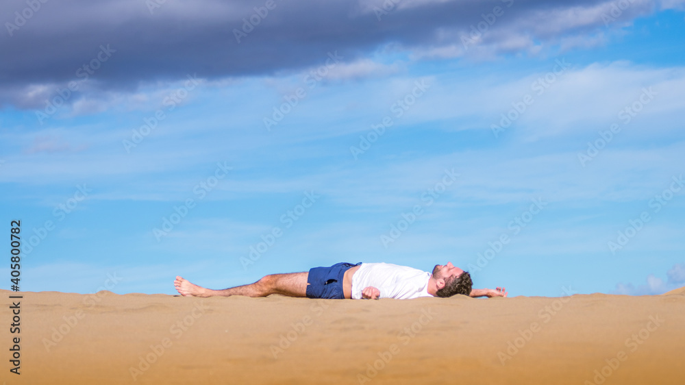 Young man lying on the sand in Gran Canaria