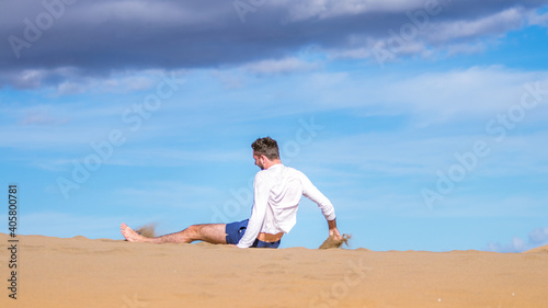 Young man sitting in the desert in Gran Canaria © Antoine