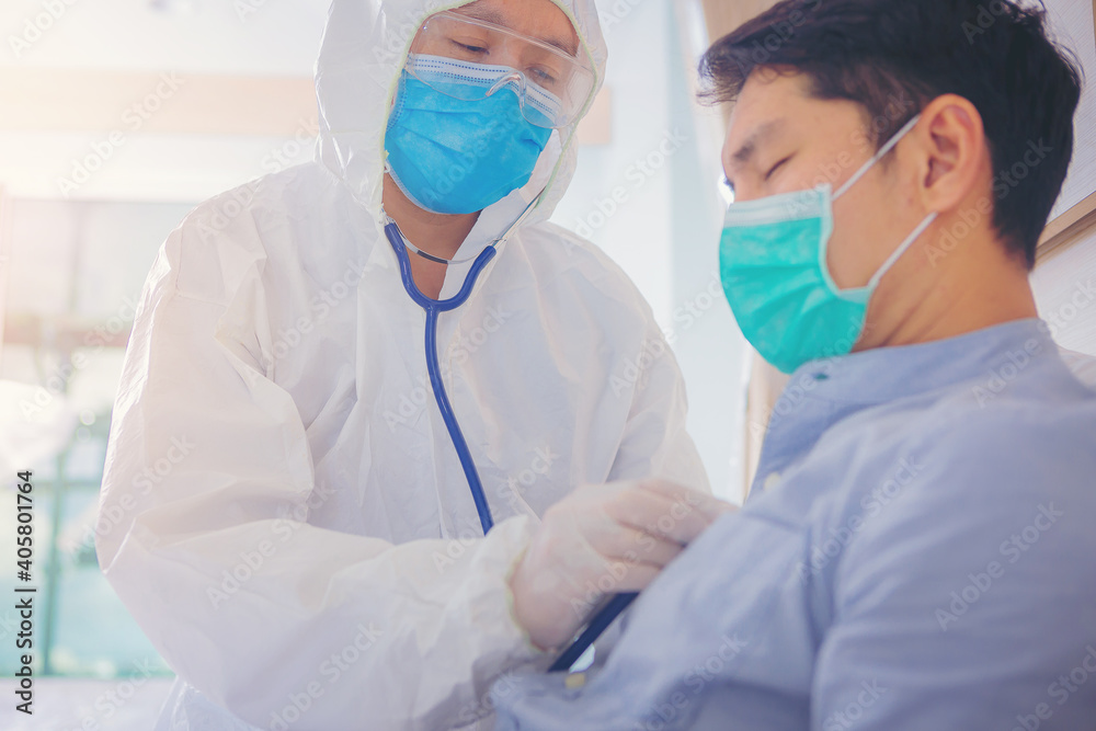 Doctor in the protective suits and face mask examining male patient flu from virus with stethoscope in the control area at hospital.