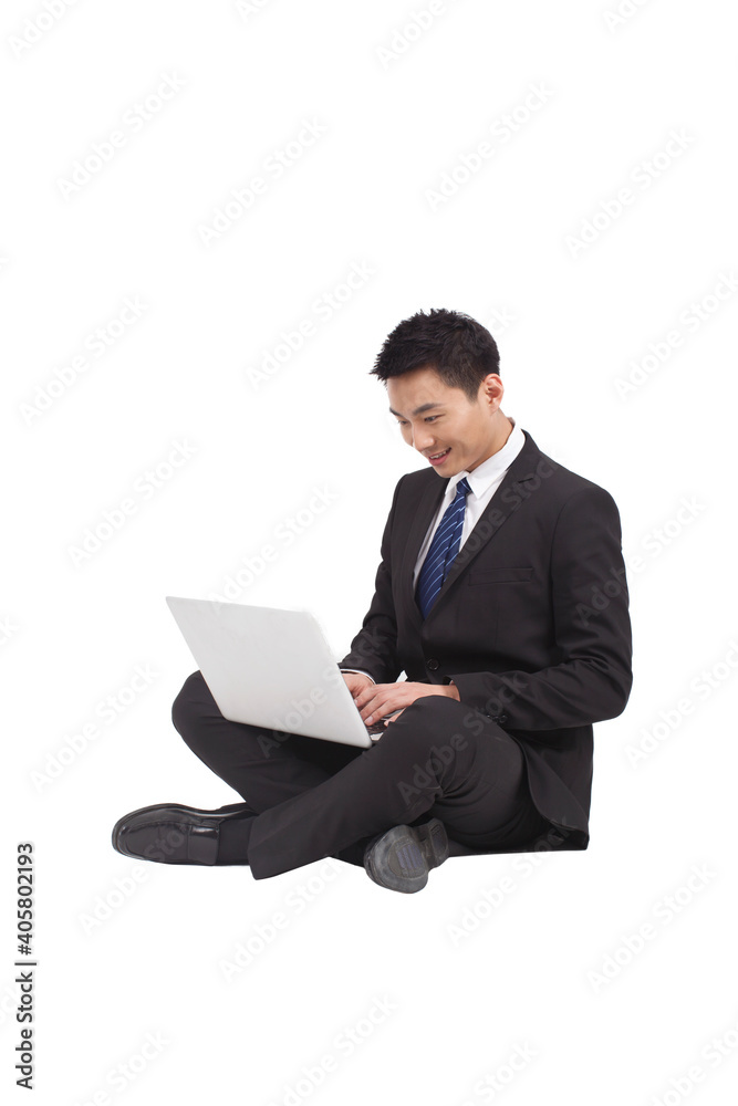 Portrait of young businessman sitting on ground,using laptop Portrait of young businessman sitting on ground,using laptop