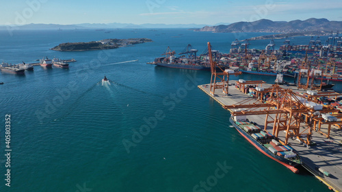 Aerial drone photo of container truck size cargo vessel approaching international container loading - unloading logistics terminal of Piraeus, Perama, Attica Greece