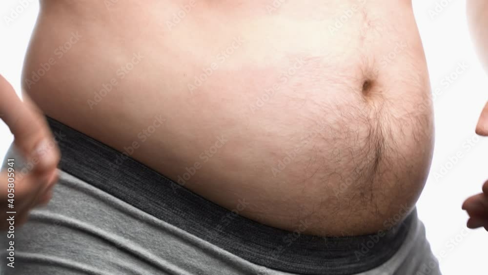 Close up fat man touch the Belly doing massage shaking. He very fat and has problem with stomach ache because he eat to much. Close up fat man touch the Belly doing massage shaking. He very fat and has problem with stomach ache because he eat to much.