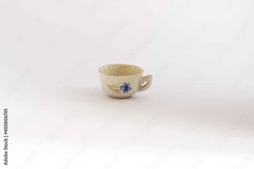 Ceramic mini tea cup isolated on white background. Miniature blue and white ceramic tea cup.