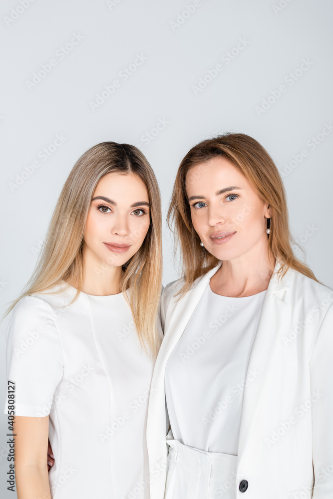 happy mother and daughter looking at camera isolated on grey, generation of women happy mother and daughter looking at camera isolated on grey, generation of women