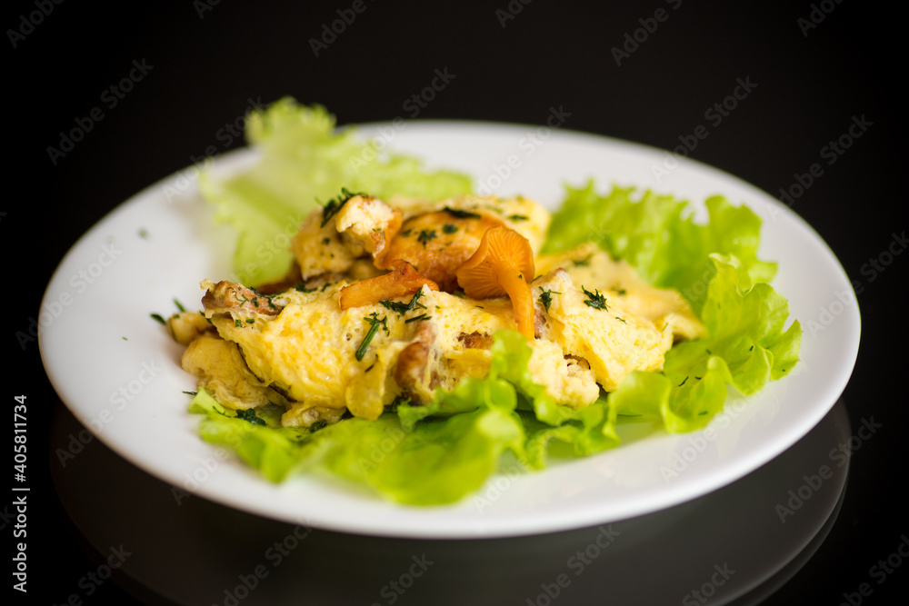 fried omelet with forest mushrooms chanterelles, on black background fried omelet with forest mushrooms chanterelles, on black background