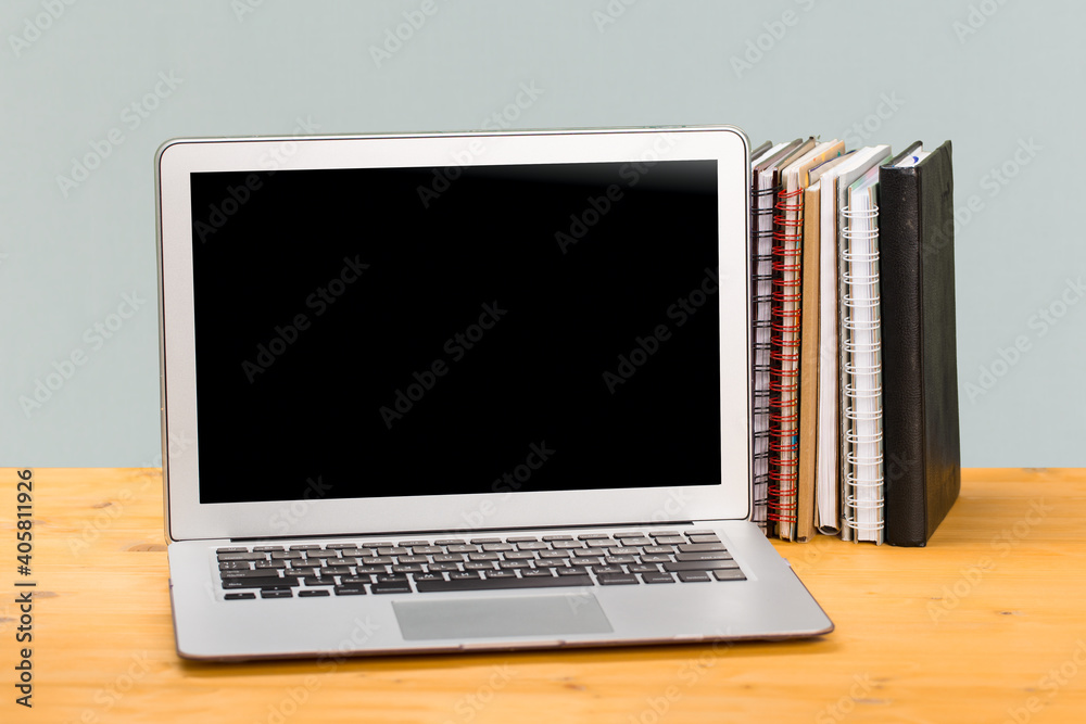 Notebook with multi-colored books on a wooden table. mocap. work from home Notebook with multi-colored books on a wooden table. mocap. work from home
